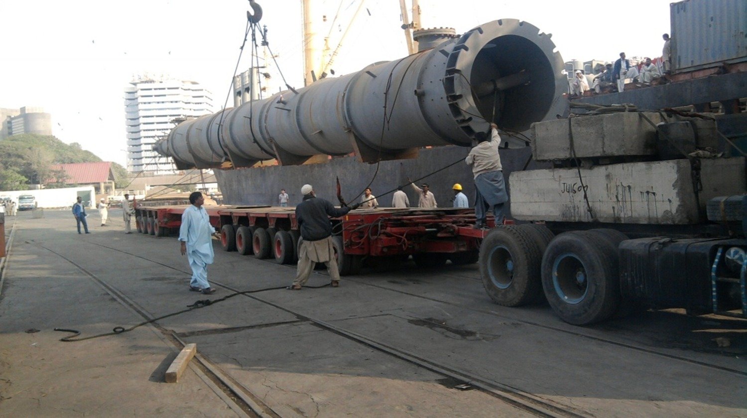Quay-side heavy-lift discharge of an oversized pressure vessel onto a multi-axle hydraulic trailer with certified rigging crews